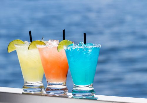 refreshing margaritas served outside with a water background as a travel concept